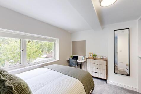 A bright and inviting bedroom featuring a large...