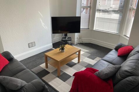 Bright, neatly presented living room with two b...