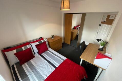Bright, well-furnished bedroom with a neatly ma...