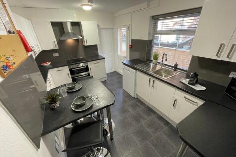 Modern galley kitchen with sleek black worktops...