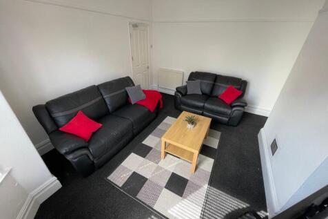 Bright, neatly furnished living room with two b...