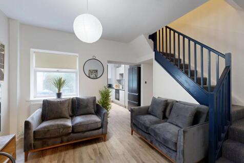 A bright and welcoming living room featuring mo...