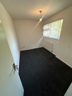 A neat and tidy single bedroom featuring dark c...