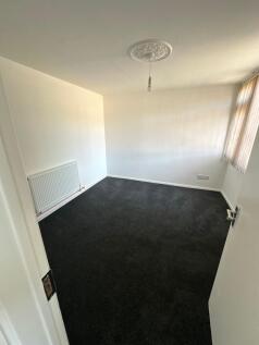 A clean and simple small room with dark carpet ...