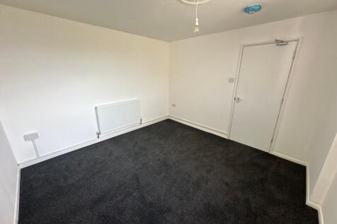 A freshly painted single bedroom with clean whi...