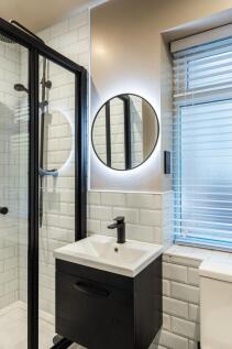 Modern bathroom with a black-framed glass showe...