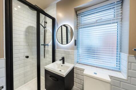 Bright, modern bathroom with a frameless glass ...