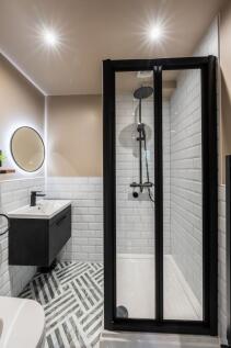 Modern bathroom with a glass-enclosed shower, s...