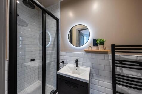 Contemporary bathroom with a glass-enclosed sho...