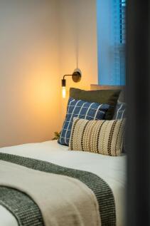 Stylish double bedroom with layered cushions, w...