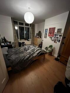Comfortable double bedroom with a wooden bed fr...