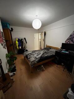 Bright, simply furnished bedroom with wooden fl...