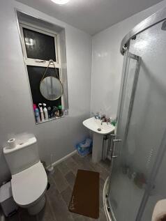 Compact modern bathroom with a corner glass sho...