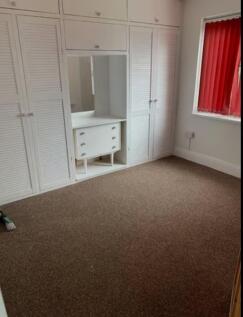 A spacious and tidy double bedroom featuring am...