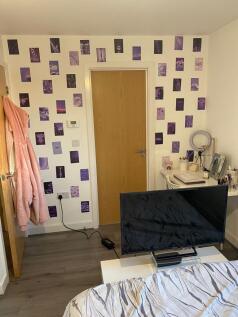 Bright, neatly arranged bedroom with modern lam...