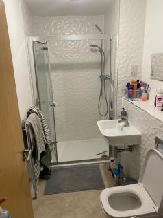 Bright, modern bathroom with patterned white wa...