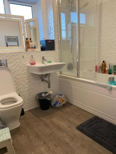 Bright modern bathroom with a shower-over-bath,...