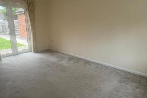 Bright, neutral living room with full-height gl...