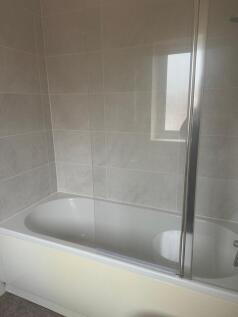 Bright, modern bathroom with a clean white bath...