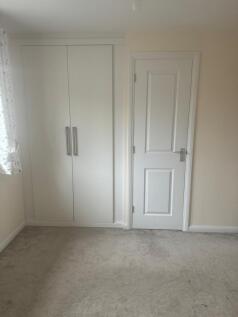 Bright, neutral bedroom with built-in double wa...