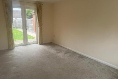 Bright living room with neutral décor, full-hei...