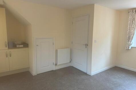 Bright neutral kitchen area with built-in cupbo...