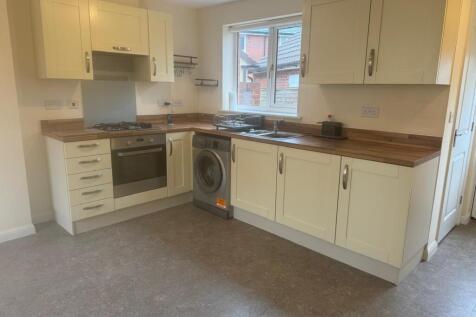 Bright, modern fitted kitchen with cream shaker...