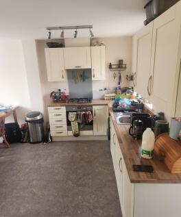 Bright galley-style kitchen with cream shaker c...