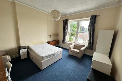 Bright double bedroom with a large sash window ...