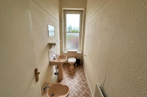 Narrow bathroom with matching pastel sanitarywa...
