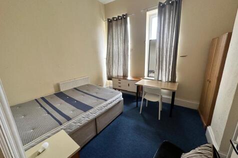Bright double bedroom with two tall windows, ne...