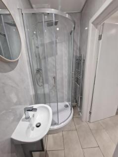 Modern bathroom with a curved glass shower encl...