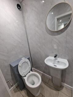 Compact modern WC with a white toilet and corne...