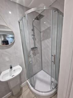 Bright, modern bathroom with a corner glass sho...