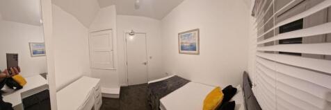 Neat, simply furnished single bedroom with a co...