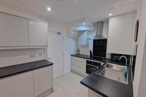 Modern fitted kitchen with sleek black worktops...