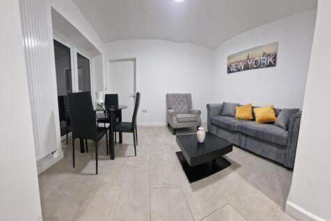 Bright, modern living room with a grey sofa acc...