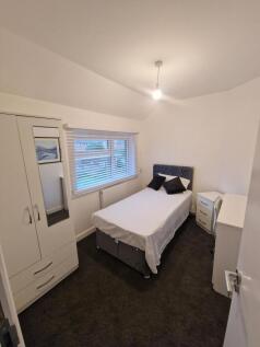 Bright, neatly furnished bedroom featuring a co...