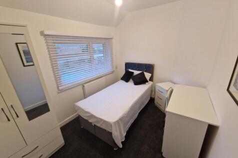 Bright, neatly furnished single bedroom with a ...