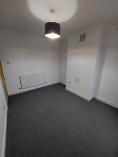 Simple, freshly painted bedroom with neutral ca...