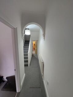 Long bright hallway with decorative archway, ca...