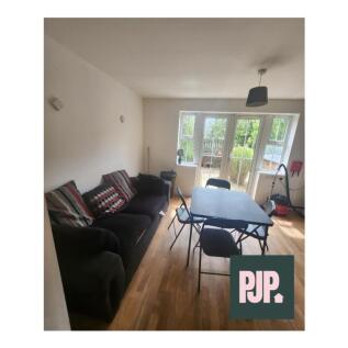 Spacious living room featuring large windows th...