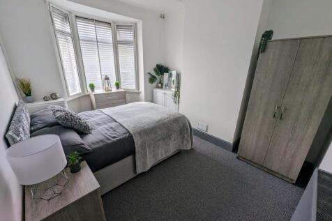 Bright, neatly styled double bedroom with a com...