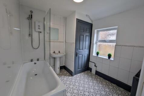 Bright, modern bathroom with patterned tiled fl...
