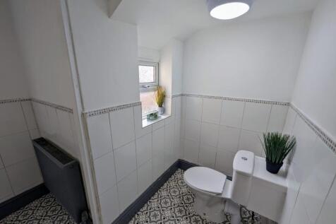 Bright, freshly tiled bathroom with patterned f...