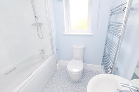 Bright, modern bathroom with a bathtub and show...