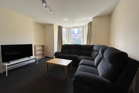 Bright bay-front living room with a large, comf...