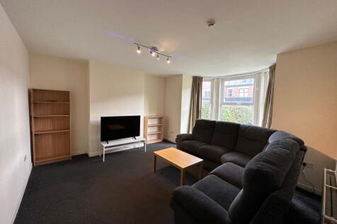 Bright, spacious living room with a large bay w...