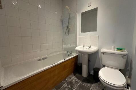 Well-kept bathroom with a fitted bathtub and sh...