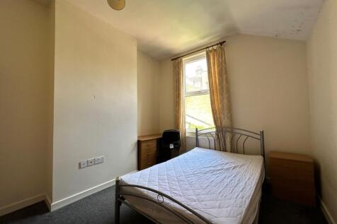 Bright double bedroom with a metal bed frame, n...